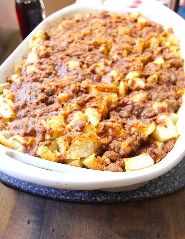 Side shot of a casserole dish of baked cinnamon apple French toast.