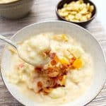 Two bowls of chunky loaded potato soup, on a placemat.