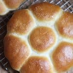 Overhead shot of homemade dinner rolls, in a loaf of 7 rolls, on a wire rack.