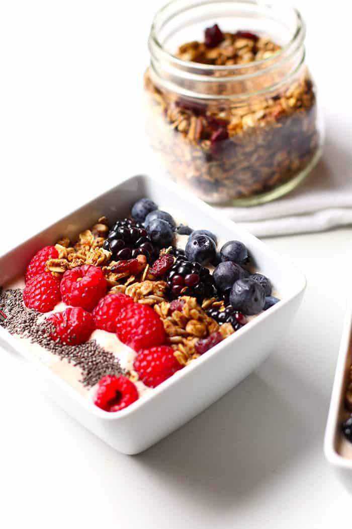 An Acai Smoothie Bowl, with a jar of granola in the background.