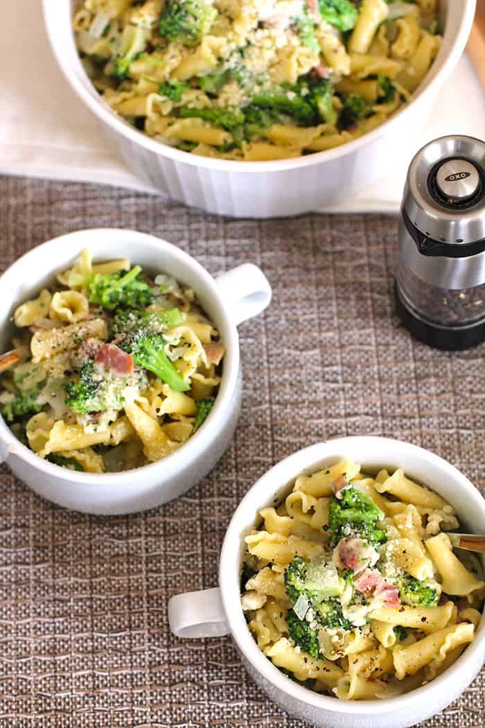 Overhead shot of two servings of broccoli pasta in white bowls.