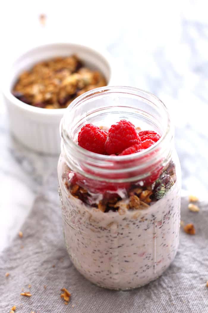 Overhead view of a jar of overnight oats with raspberries on top.