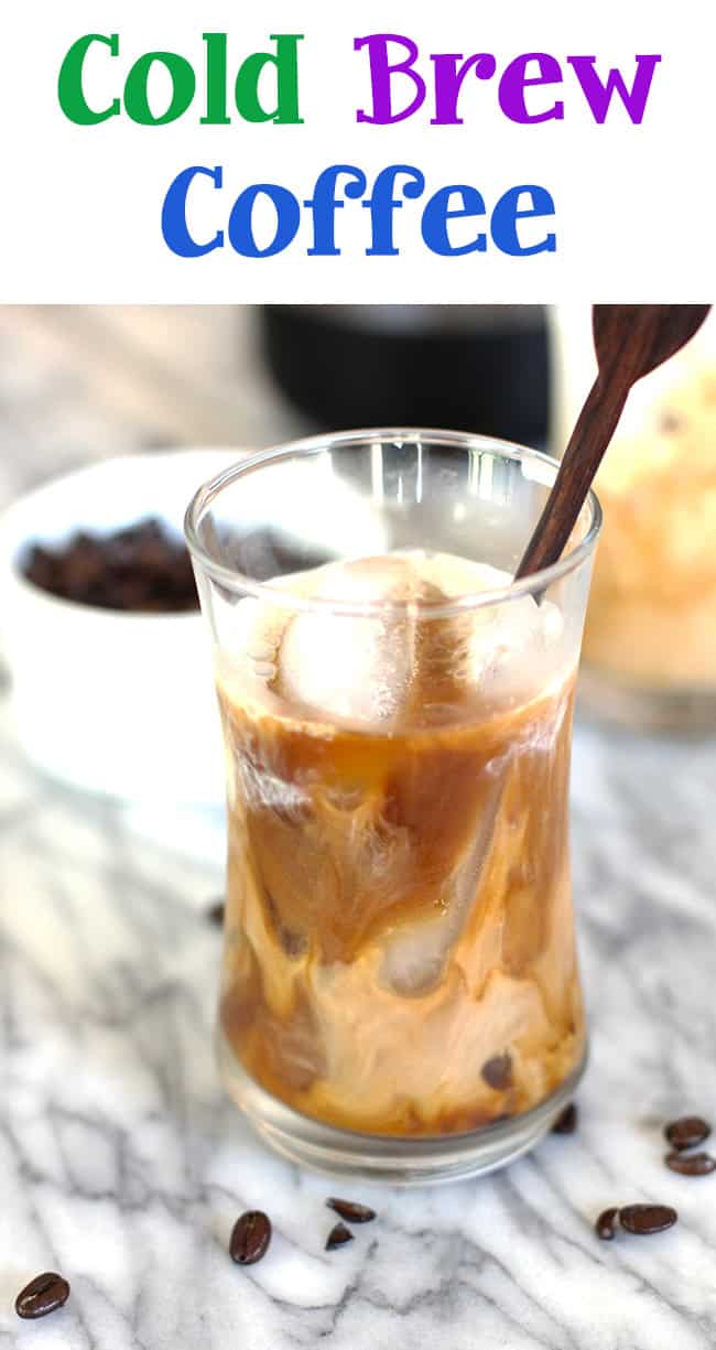 A glass of cold brew coffee, with milk and a stir stick.