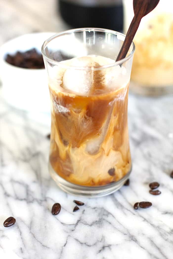 Side view of a just poured cold brew coffee, with ice and a stir stick.