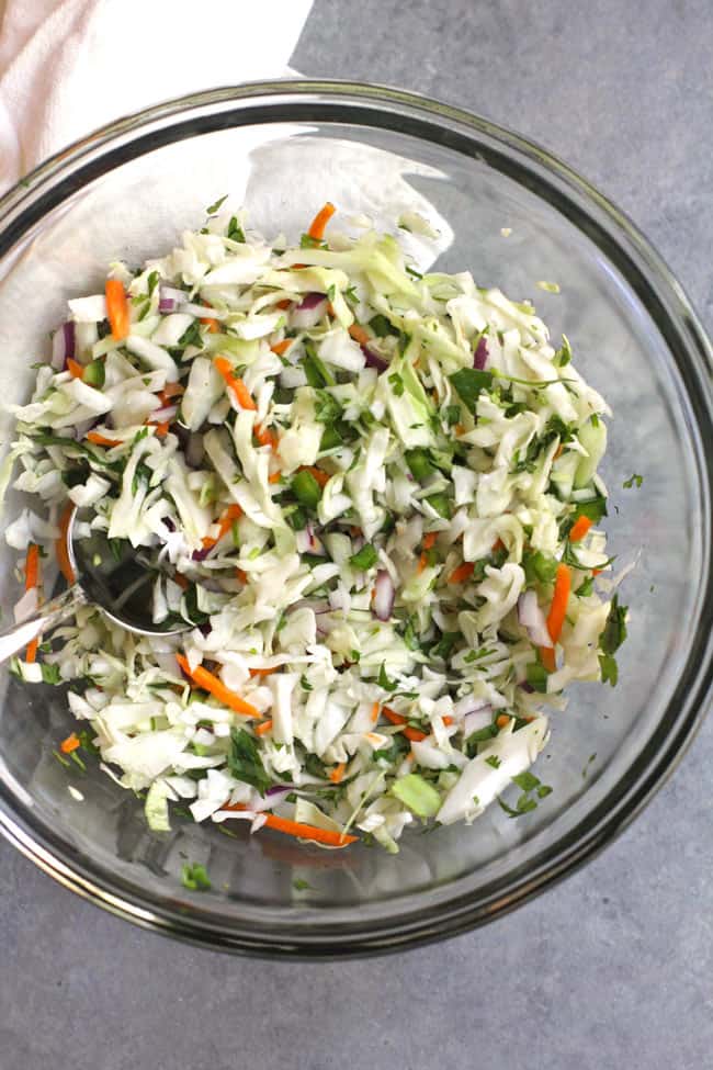 Overhead shot of the crunchy slaw in a glass bowl.