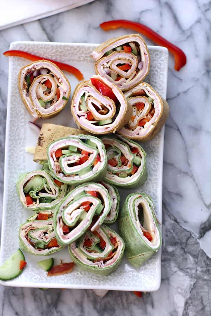 Overhead shot of a tray of turkey club roll ups.