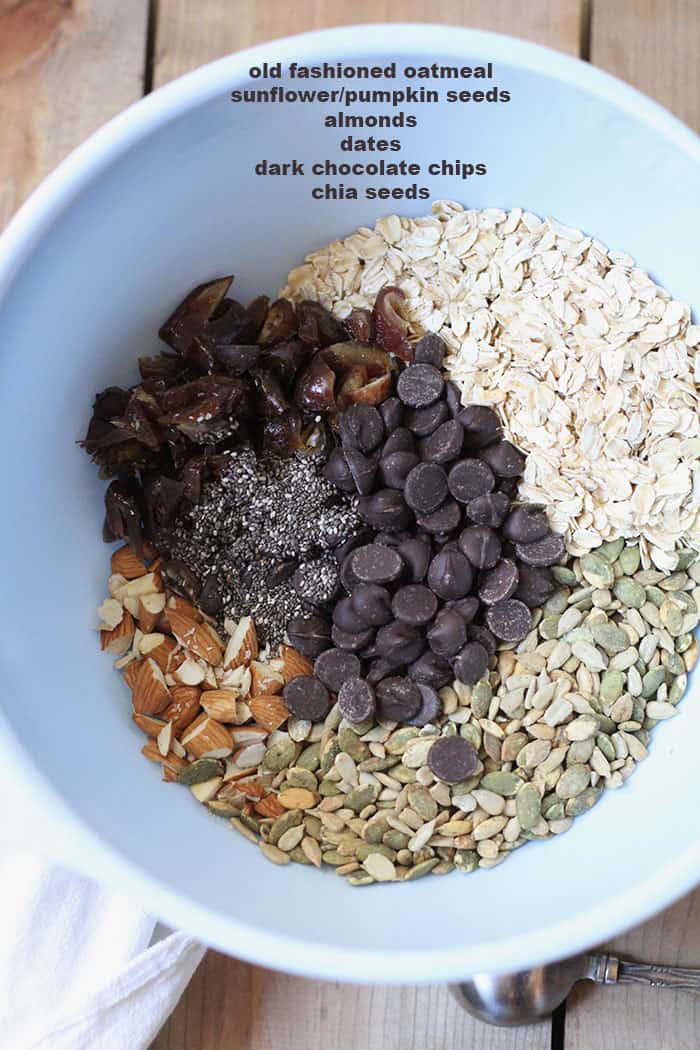 Overhead shot of blue mixing bowl full of energy bite ingredients, separated by ingredient.