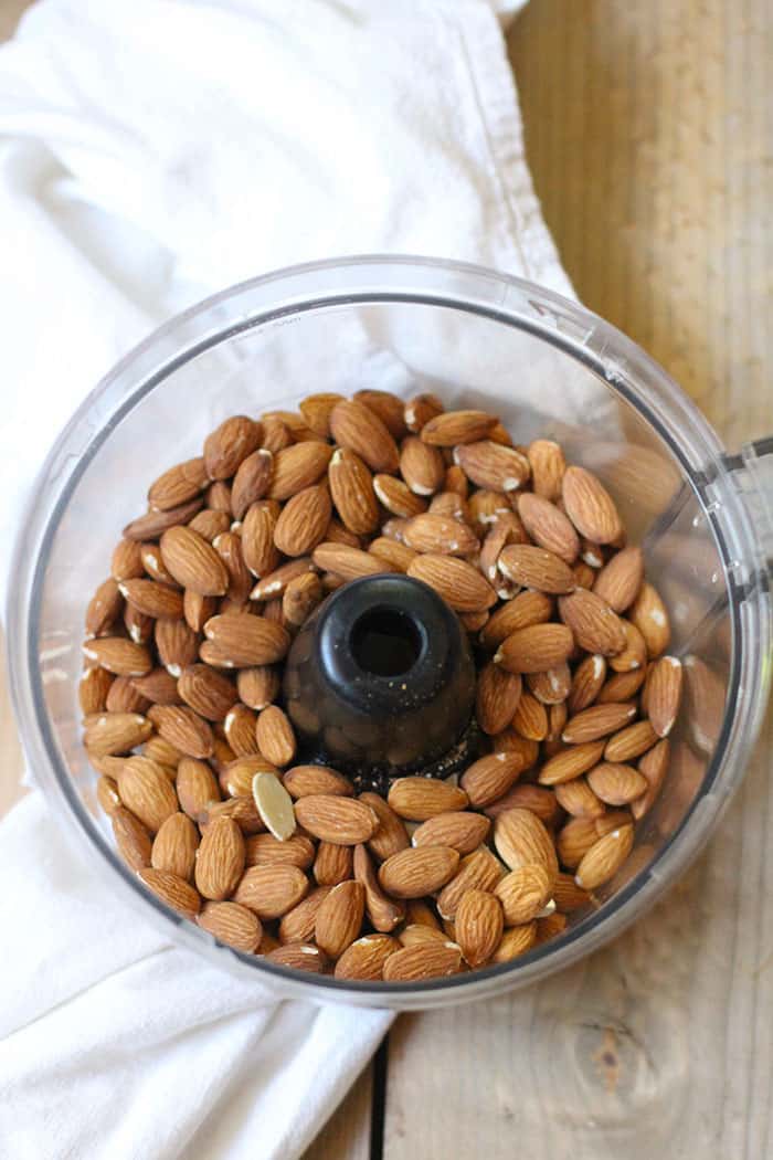 A food processor with the almond butter after processing.