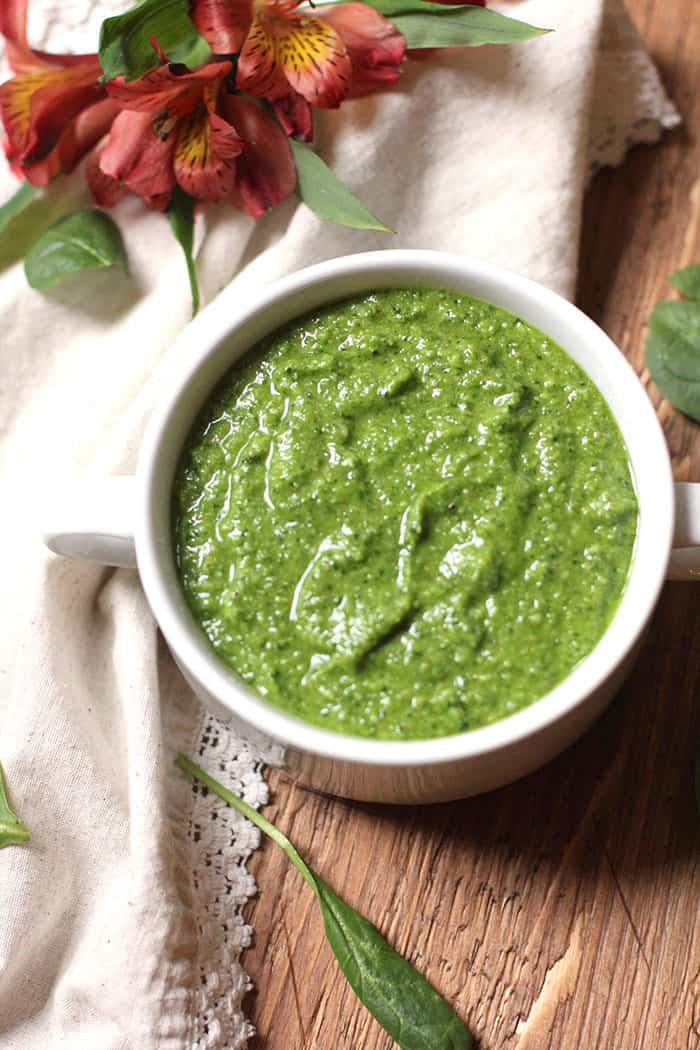 Overhead shot of the spinach pesto sauce in a white bowl.