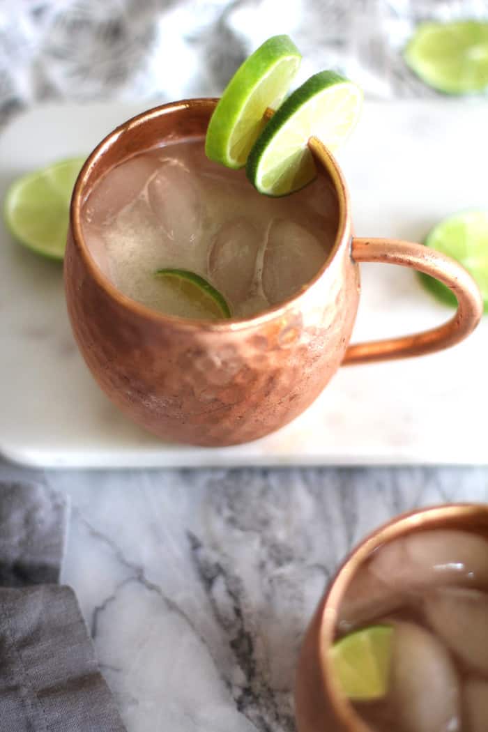 Overhead view of two classic Moscow mules  in copper mugs with lime wedges.