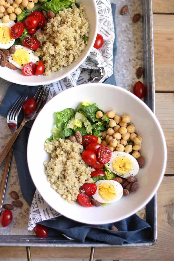 Overhead shot of two bowls of protein packed quinoa salad, on a gray tray.