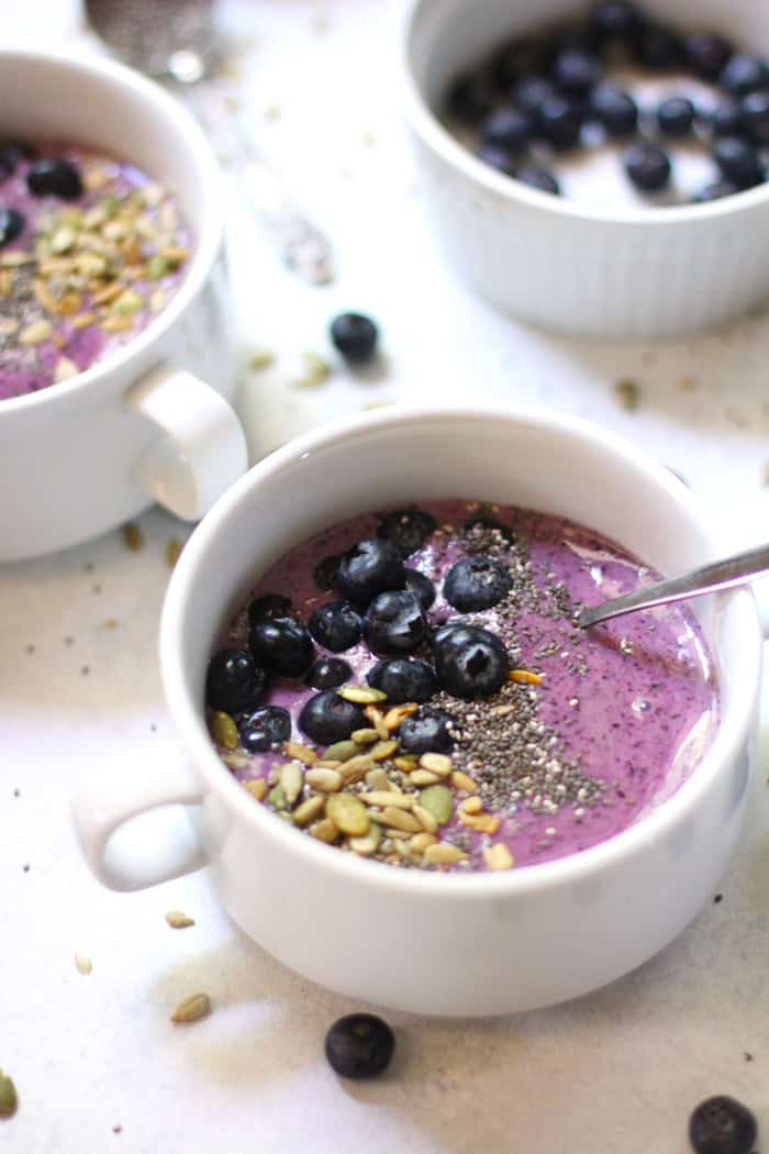 Side shot of two blueberry smoothie bowls.