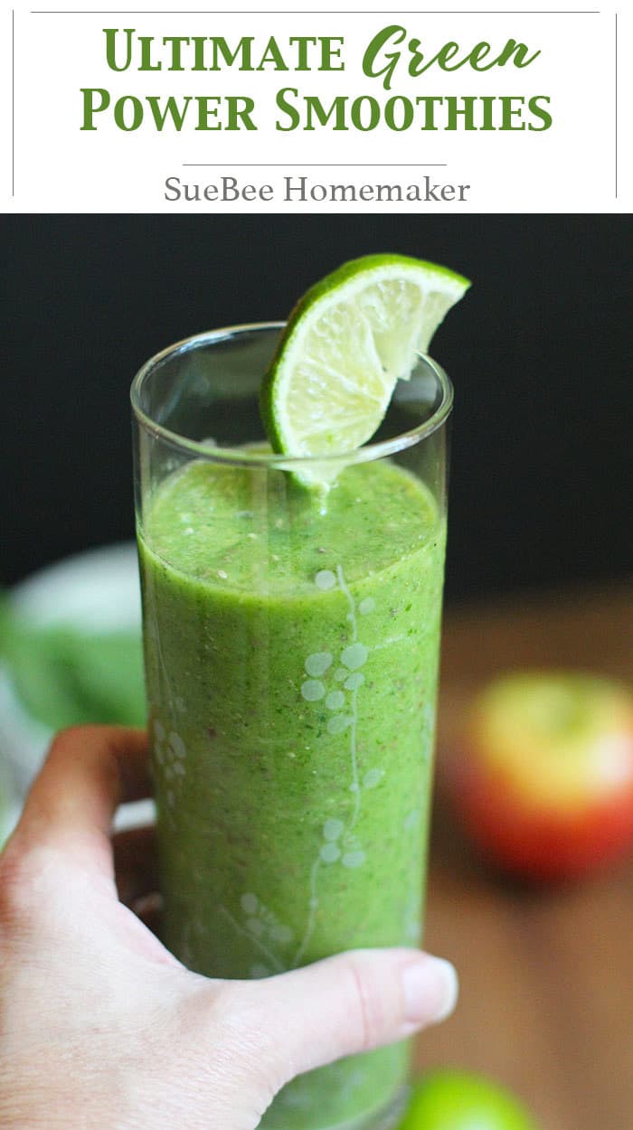 A hand holding an ultimate green power smoothie, with a lime wedge.