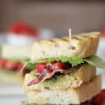 A double stacked BLT sandwich with pesto sauce.
