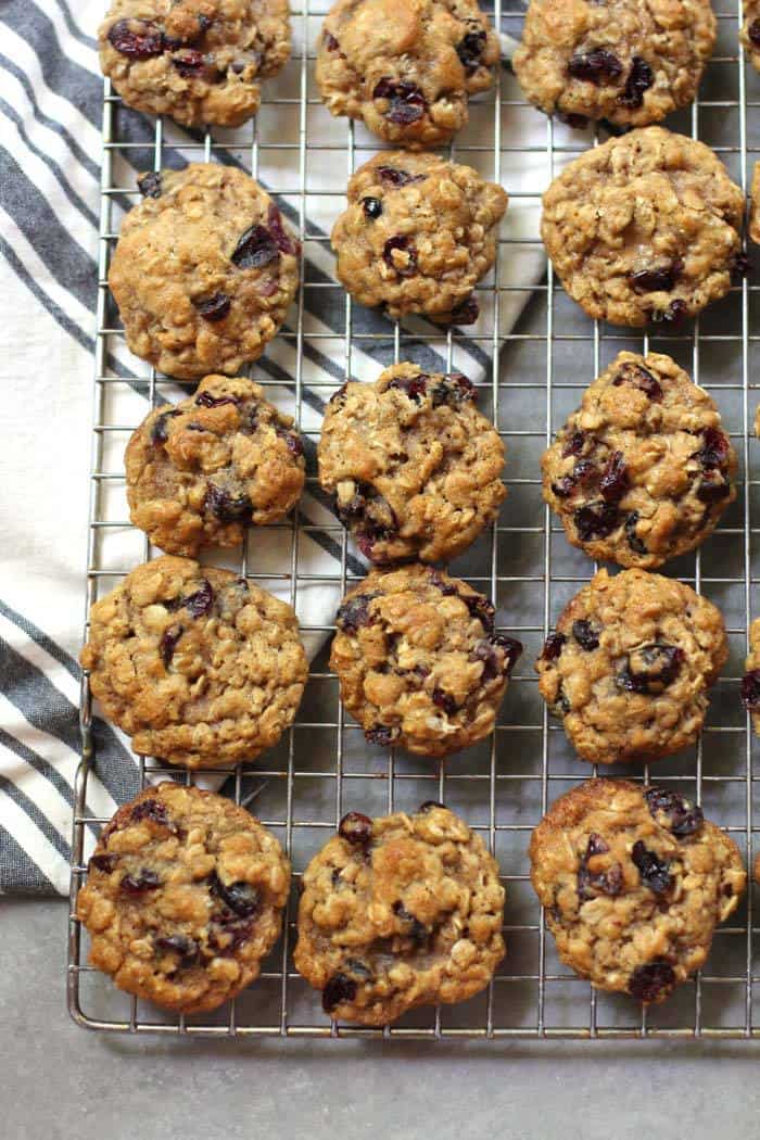 Overhead shot of Mini Cranberry Oatmeal Cookies on a wire cooling rack, with a gray and white napkin.