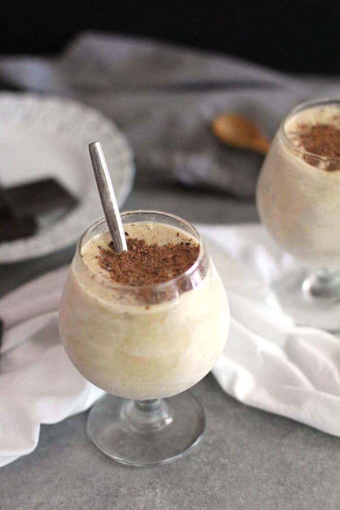 Side shot of Frozen Kahlua Cocktails, on a gray background with a white napkin.