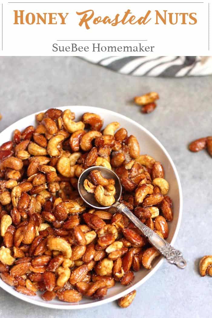 Overhead shot of a bowl of honey roasted nuts, with a spoon inside.