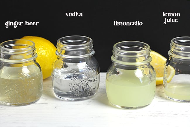 Side shot of four small jars showing the ingredients used for Limoncello Moscow mules.