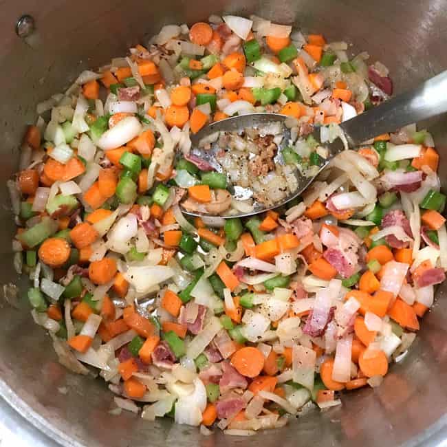 Overhead shot of cooking the mirepoix plus bacon, in a large stockpot.