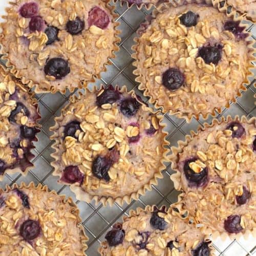 Overhead shot of Blueberry Baked Oatmeal Cups in jumbo liners, on a wire cooling rack.