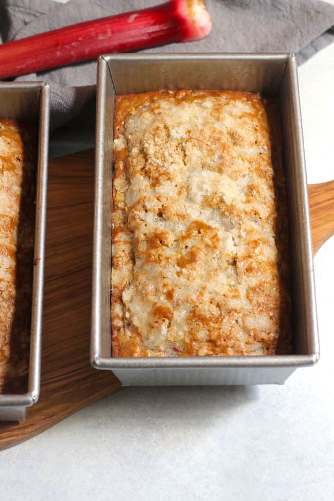 Side shot of a pan of rhubarb nut bread, on a white background.