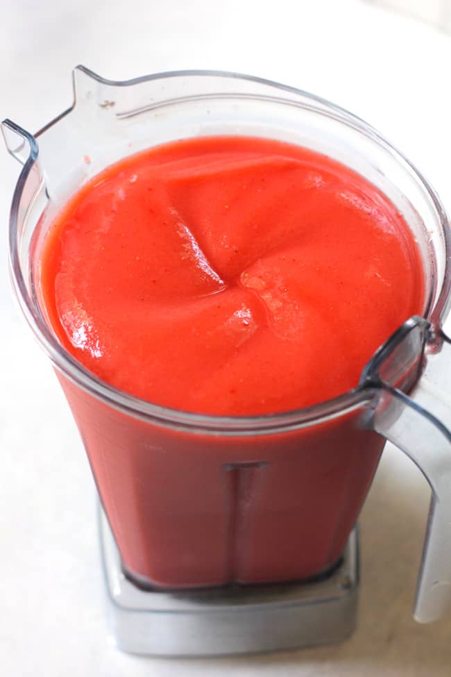 Side shot of a pitcher full of strawberry lemonade vodka slush, ready to drink after blending.