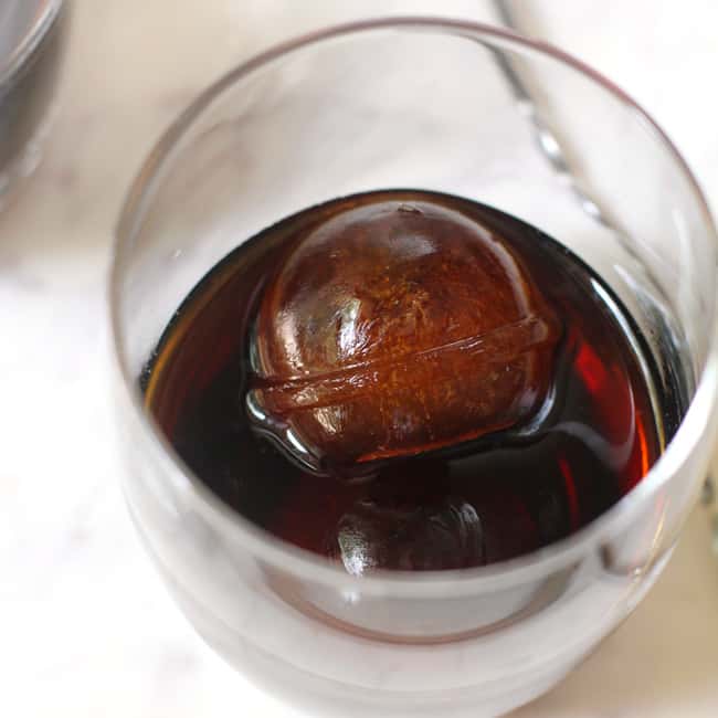 Overhead shot of coffee ice cubes in a glass with cold brew added.