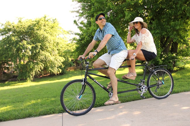 Mike and Sue riding a tandem bike in a park in Texas.