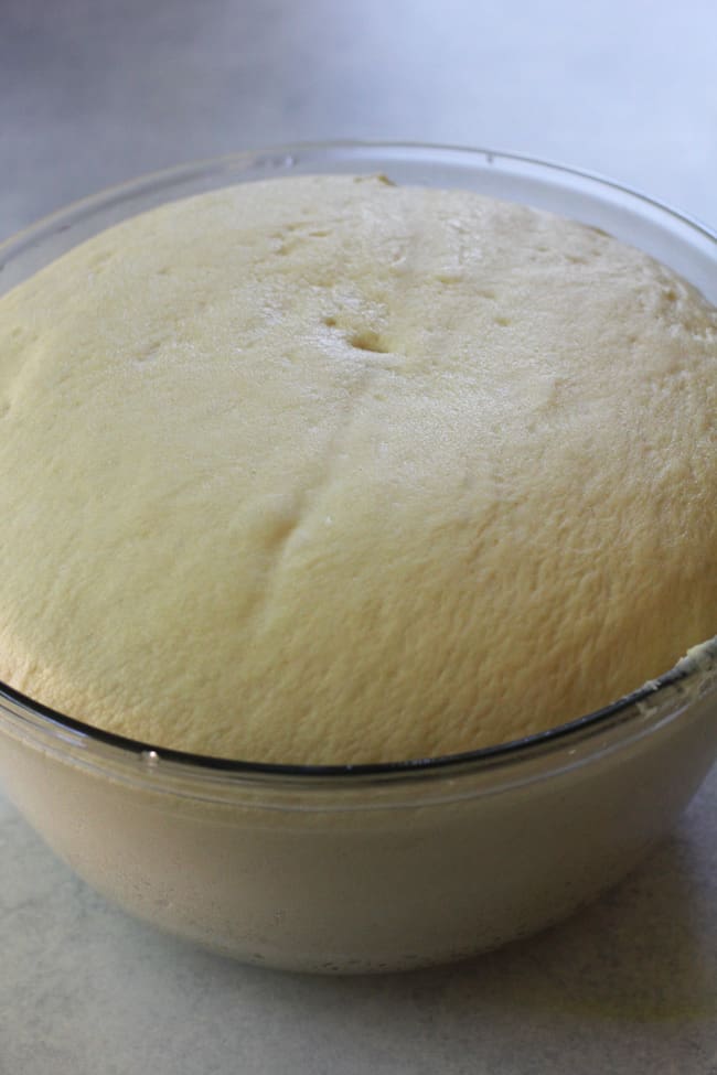 The brioche dough after doubling in size, in a glass bowl.