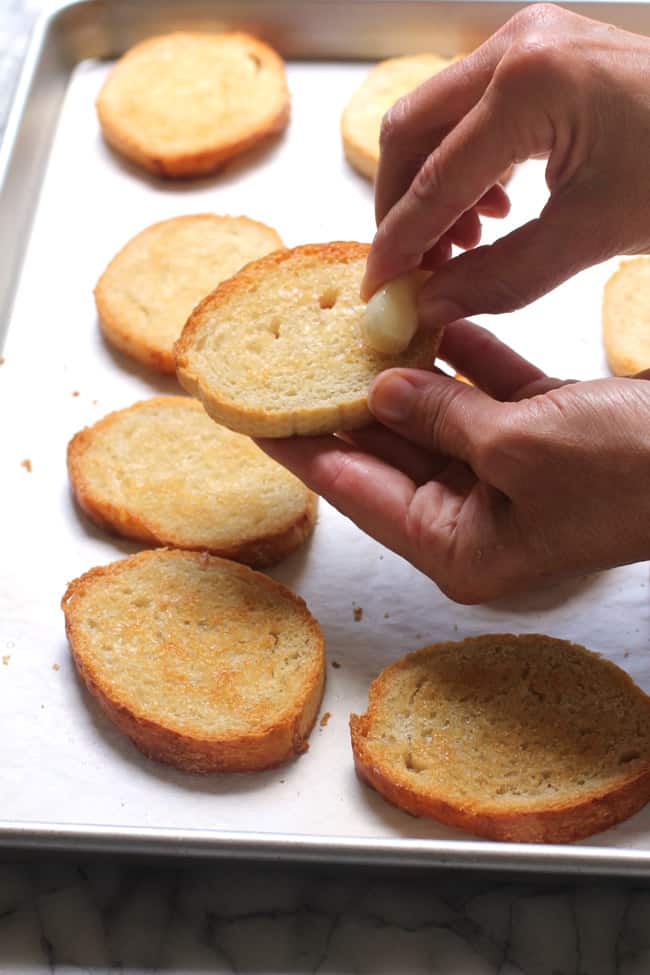 My hands rubbing the garlic on the toasted bread.