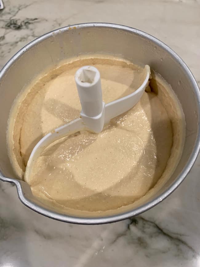 Overhead shot of homemade peanut butter ice cream in the canister of a churner, frozen and ready to eat.