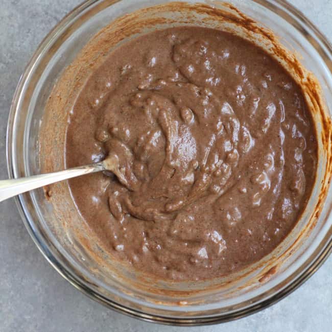 Overhead shot of a bowl of chocolate cake batter, with a spoon.