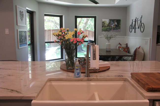 A shot of the sink with the kitchen seating table in the background.