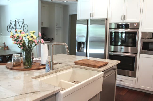 A shot of the farmhouse style sink and the appliances wall in the background.