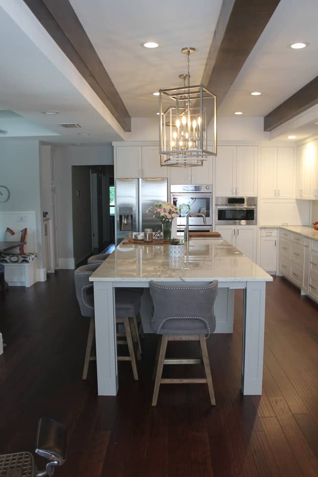 A shot of the large kitchen island and beams overhead.