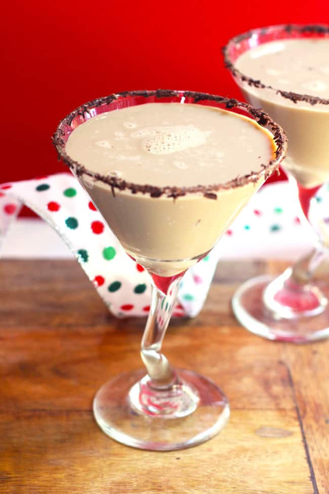 Side shot of two chocolate martinis, against a red background.