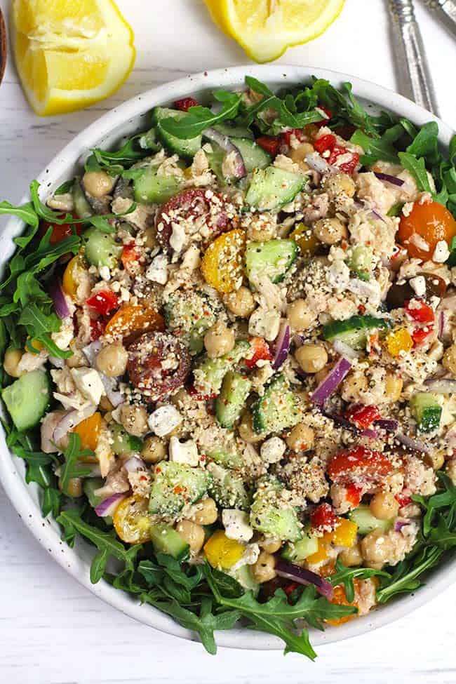 Overhead shot of a bowl of chickpea tuna salad on a bed of greens.