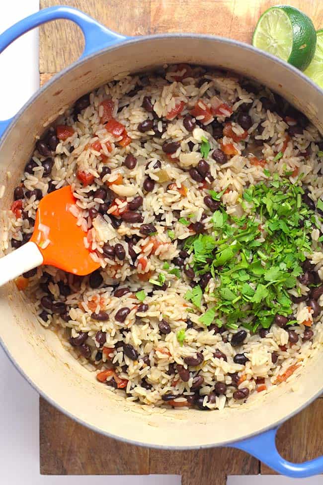 A blue stock pot of Spanish Rice and Beans, with cilantro on top.