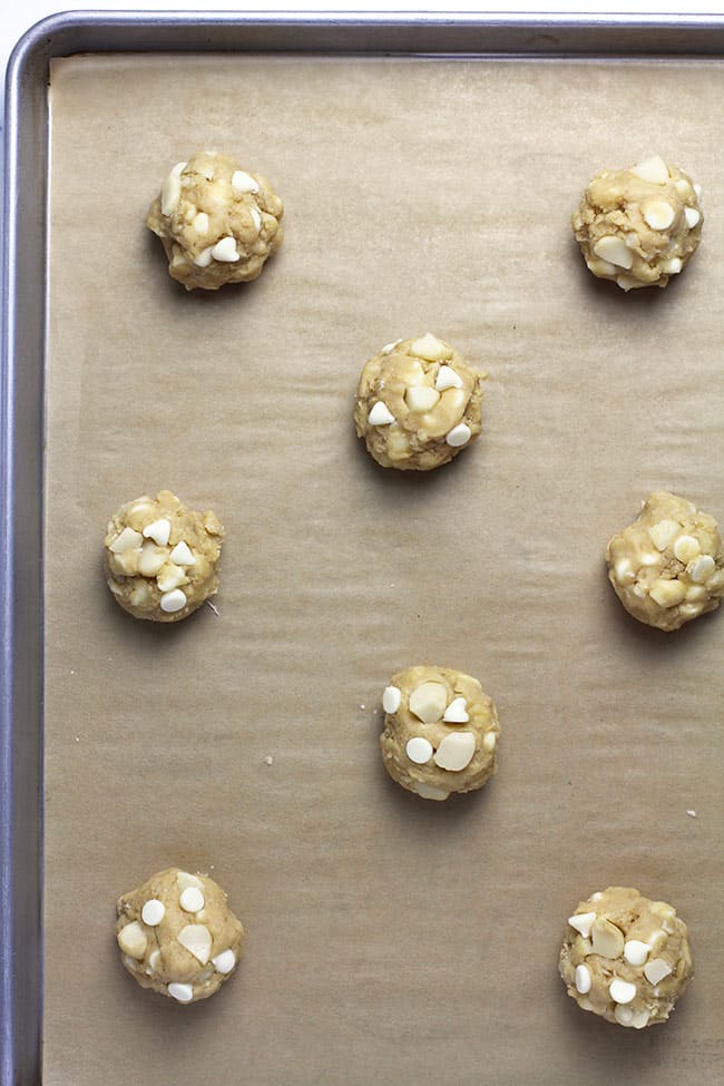 A baking sheet with the cookie dough balls ready to bake.