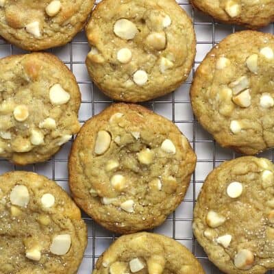 A bunch of white chocolate macadamia nut cookies on a cooling rack.