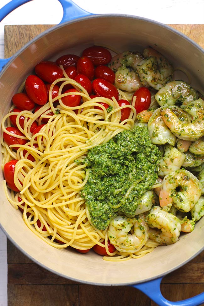 A stock pot of shrimp pesto pasta, divided by ingredient.