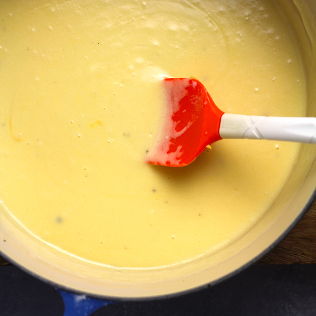 A closeup of the creamy cheese sauce, with a spatula.