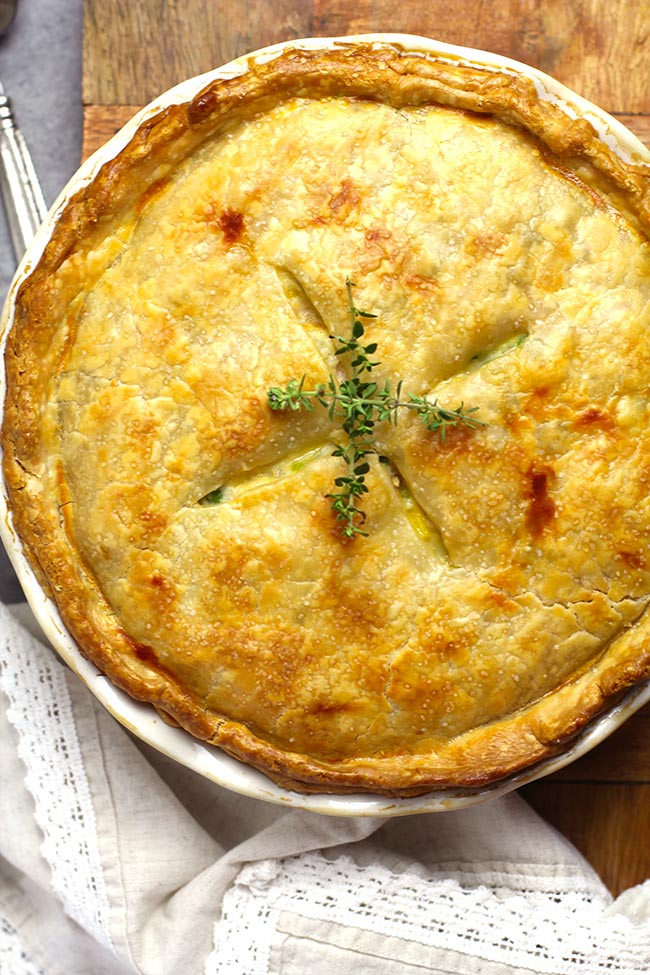 Overhead view of a just baked chicken pot pie, with thyme on top.