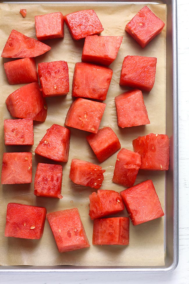 A baking sheet with cubed watermelon ready to freeze.