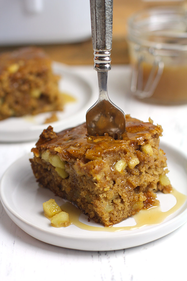 Side shot of a piece of apple spice cake with caramel sauce.