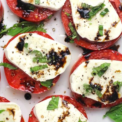 A partial plate of caprese salad with balsamic glaze.