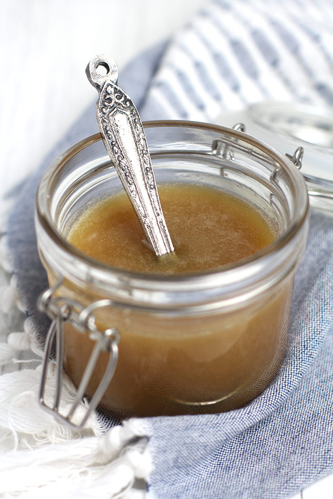 A mason jar of caramel sauce, with a measuring spoon.