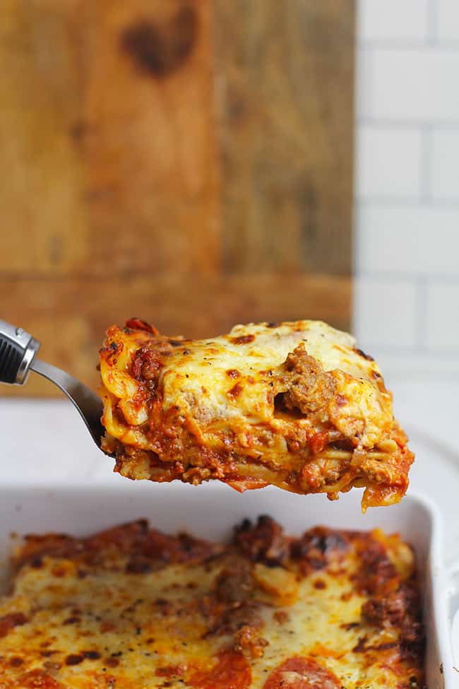 A spatula holding up a piece of the ultimate lasagna, showing the layers.