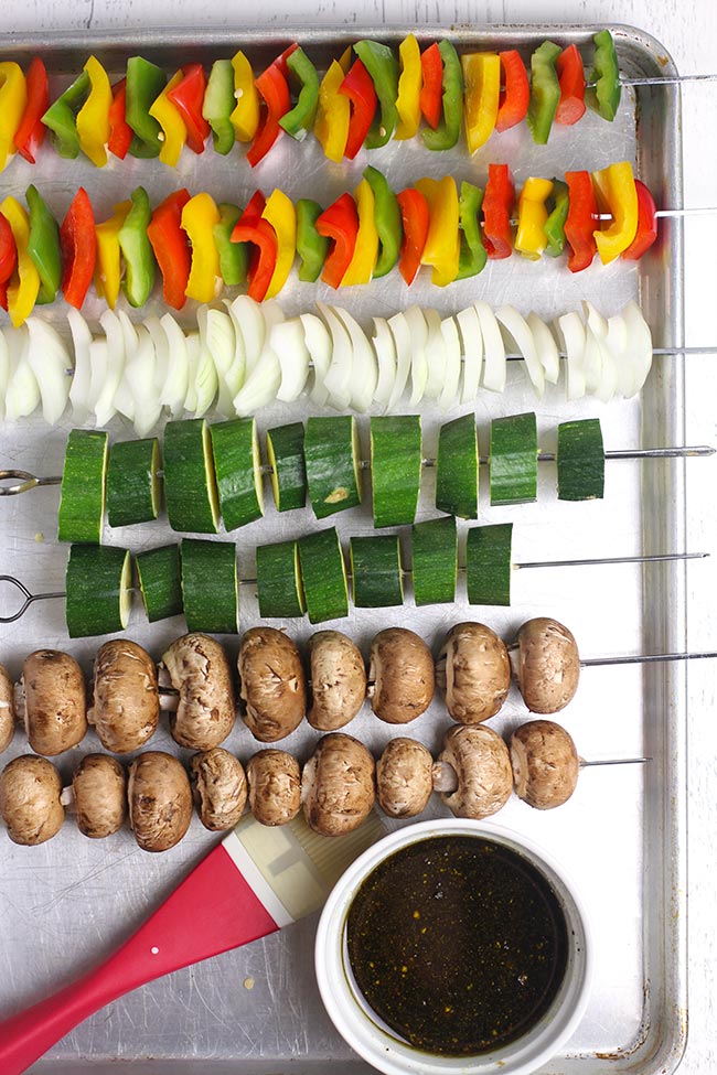 A baking sheet with veggie skewers by ingredient.