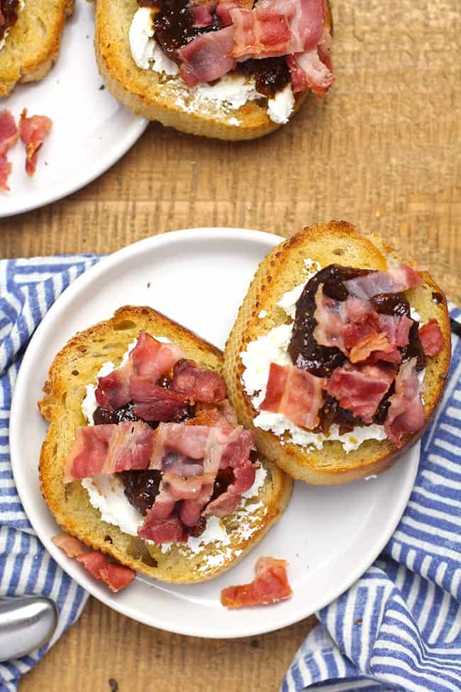 Two plates of bacon fig crostini appetizers.